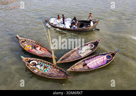 Dhaka, Bangladesh - 31 août 2024 : vue aérienne de petits bateaux de pêche regroupés, leur contenu coloré contrastant avec les eaux boueuses o Banque D'Images