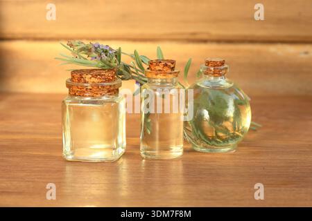 huile essentielle de lavande dans une bouteille en verre sur fond en bois Banque D'Images