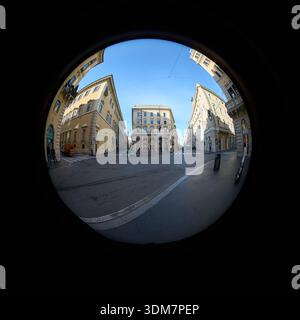 Vue en fisheye d'une intersection tranquille sur la Via del Corso à Rome, Italie, lors d'un matin d'hiver clair en janvier 2026 Banque D'Images