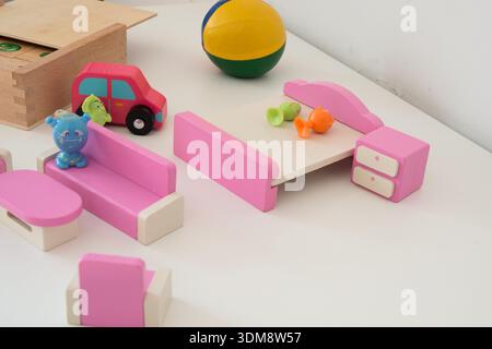 Salle de jeux avec meubles de maison de poupée rose et petites poupées en plastique Banque D'Images