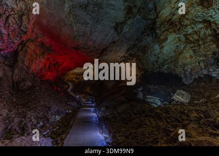Chemin de grotte illuminé guidant les visiteurs à travers les formations géologiques accidentées du paysage souterrain de Ravno en Bosnie-Herzégovine. Banque D'Images