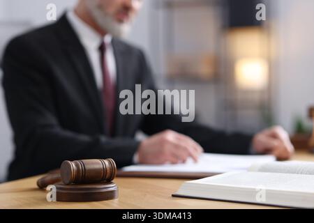 Notaire en costume faisant la paperasse à la table en bois dans le bureau, se concentrer sur le marteau Banque D'Images