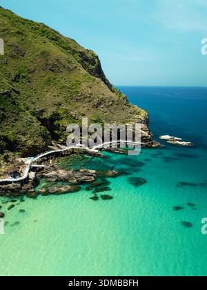 Vue aérienne drone Green Cliff Path Turquoise Ocean Tropical Coast Rocky Shoreline Banque D'Images