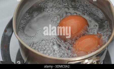 Œufs bouillants avec casserole en acier inoxydable pour le petit déjeuner Banque D'Images