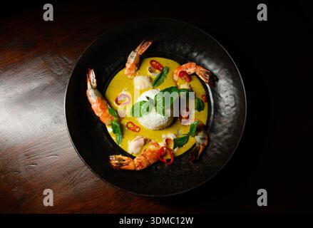 Une assiette de nourriture avec des crevettes et du riz. Les crevettes sont disposées en cercle autour du riz Banque D'Images