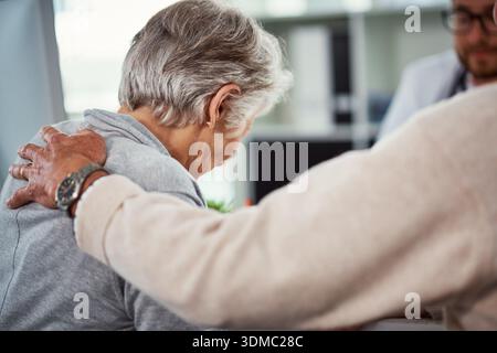 Confort, triste et femme senior avec médecin pour les mauvaises nouvelles, les résultats médicaux et l'empathie. Couple âgé, consolant et soignant avec terminal Banque D'Images
