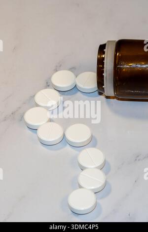comprimés blancs renversant de la bouteille de pilule brune Banque D'Images