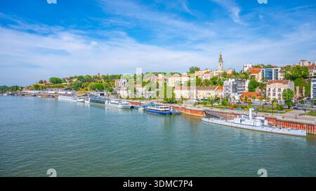 La Sava traverse Belgrade, et présente des bâtiments dynamiques et une végétation luxuriante le long des rives. Les bateaux sont amarrés, et l'horizon révèle un mélange d'histoire et de modernité. Banque D'Images
