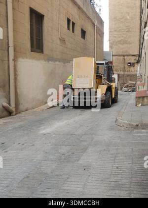 Détail d'un vieux chariot élévateur diesel endommagé, l'opérateur regarde le moteur avec le capot ouvert. Dans les œuvres de Barcelone Banque D'Images