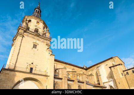 Vue en bas angle de la cathédrale Santa Maria de Vitoria-Gasteiz, montrant son clocher en pierre, son architecture gothique et ses murs historiques sous un ciel bleu clair en plein jour. Photo de haute qualité Banque D'Images