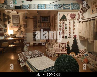 Détail de l'intérieur d'un beau magasin d'articles ménagers artisanaux et de qualité, magasin confortable avec un éclairage chaleureux, housses de coussin sencen, couvertures, Banque D'Images