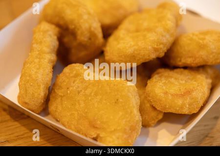 Vue rapprochée des appétissantes pépites de poulet frites croustillantes dorées, parfaites pour illustrer les menus de restaurant, les promotions de restauration rapide ou les collations pratiques Banque D'Images