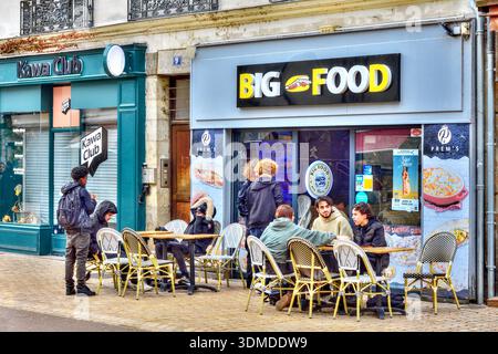 Des groupes d'étudiants à l'heure du déjeuner se sont assis devant un restaurant de restauration rapide 'Big Food' - Tours, Indre-et-Loire (37), France. Banque D'Images