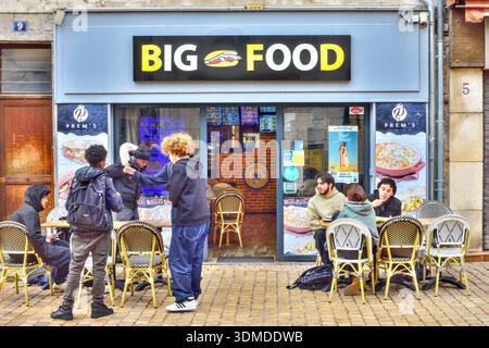 Des groupes d'étudiants à l'heure du déjeuner se sont assis devant un restaurant de restauration rapide 'Big Food' - Tours, Indre-et-Loire (37), France. Banque D'Images