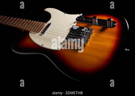 Un gros plan détaillé d'une guitare électrique Sunburst classique, en se concentrant sur le pont, le pick-up, les boutons de commande et le design emblématique du pickguard Banque D'Images