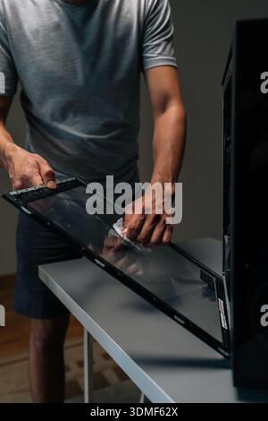 Plan vertical recadré d'un technicien en informatique essuyant le panneau de verre, éliminant l'accumulation de poussière et améliorant le flux d'air interne pour un système électronique amélioré Banque D'Images