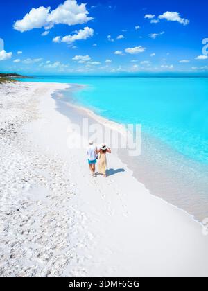 Vue aérienne d'un couple de touristes romantiques marchant sur une plage paradisiaque tropicale avec océan turquoise Banque D'Images