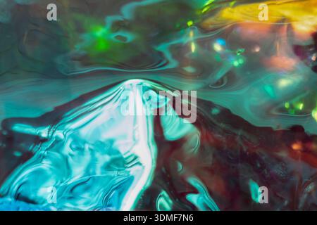 Les couleurs liquides abstraites tourbillonnent dans des reflets lumineux turquoise, sarcelle et néon éclatants sur toute la surface Banque D'Images