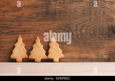 Trois biscuits de Noël savoureux sur une planche de bois avec espace pour le texte ou votre produit, boulangerie de Noël, nourriture orgainc Banque D'Images