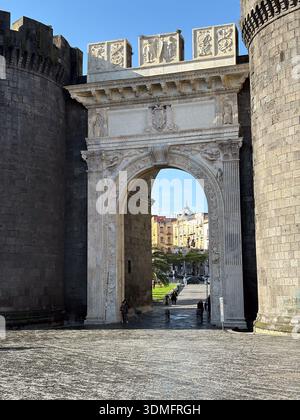 Porta Capuana, Naples (Naples). Arc de triomphe Renaissance construit en 1484, flanqué de murs de forteresse en pierre sombre. Architecture emblématique de Naples. Banque D'Images