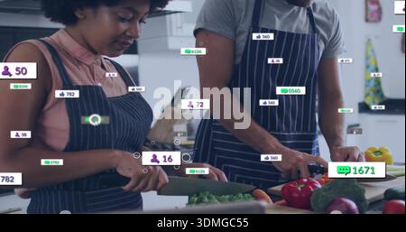 Hacher couple dans des tabliers à fines rayures foncées préparant le repas au comptoir de la cuisine avec des badges superposés Banque D'Images