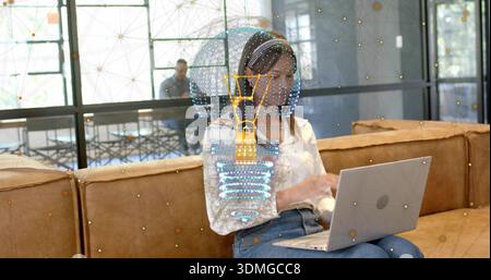 Femme de travail portant chemisier blanc, jeans bleus sur ordinateur portable argenté dans le salon de bureau, avec poignée AR Banque D'Images