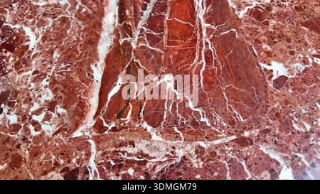 Gros plan de marbre rouge avec des motifs blancs trouvés dans la nature Banque D'Images