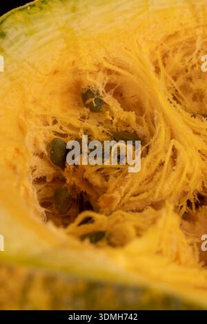 citrouille orange coupée en deux avec une chair molle et beaucoup de graines sans enveloppe, citrouille tranchée avec pulpe à pâtisserie et graines saines et nutritives Banque D'Images