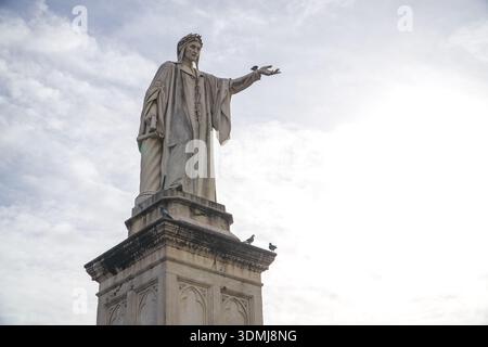 Statue de Dante Alighieri sur la Piazza Dante (Piazza Dante), Naples, Italie. Sculpture monumentale inaugurée en 1901, pigeons sur la base contre un s lumineux Banque D'Images