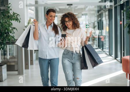 Deux amies sont dans le supermarché avec des sacs à provisions. Banque D'Images