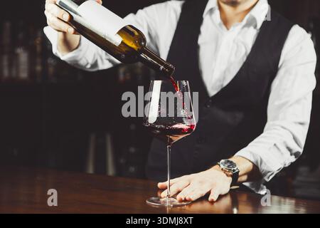 Gros plan de verre avec vin versé par sommelier Banque D'Images