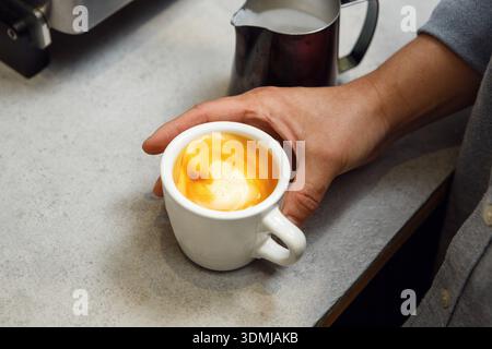 Le barista confectionne un cappuccino dans un cadre confortable le matin Banque D'Images