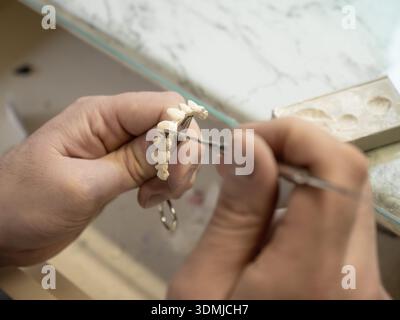 Application manuelle de céramique dentaire sur prothèse dentaire en laboratoire dentaire. Banque D'Images