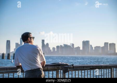 Homme regardant au-dessus du fleuve Hudson à Manhattan Banque D'Images