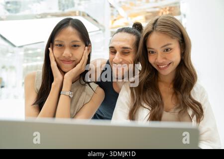 Des amis divers appréciant le contenu ensemble sur ordinateur portable Banque D'Images