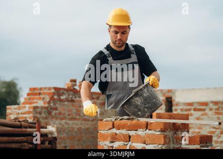 Un constructeur travaille sur le chantier de construction pendant la journée. Banque D'Images