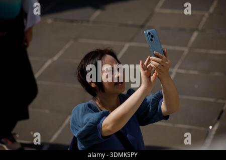 BANGKOK, THAÏLANDE-16 janvier 2026 : femme prenant une photo avec smartphone et explorant le temple thaïlandais, vue de face Banque D'Images