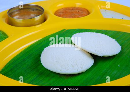 Idli sud-indien servi sur feuille de banane avec chutney et sambar dans une assiette traditionnelle Banque D'Images