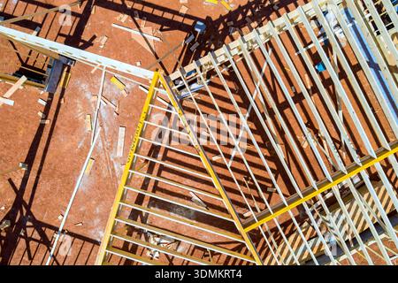 Les travailleurs construisent une structure de poutres à ossature en bois avec des morceaux de solive de toiture en bois dispersés sur le chantier de construction. Banque D'Images