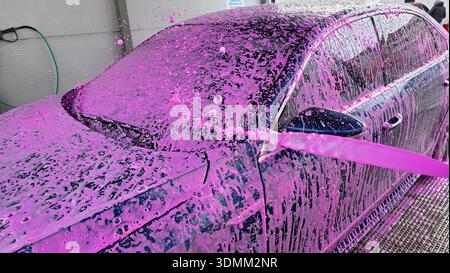 Lave-auto en mousse rose à la station de lavage auto libre-service Banque D'Images