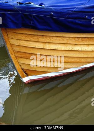Gros plan de la coque en bois de clinker construit petit bateau à flot sur l'eau formant un motif abstrait Banque D'Images