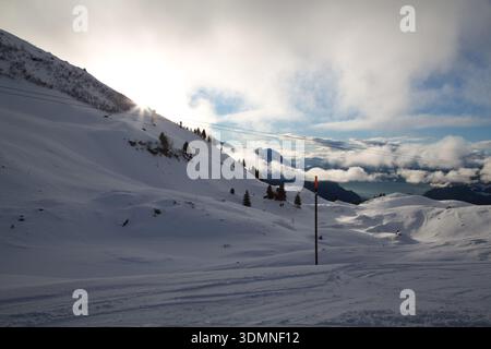 Paysage hivernal pittoresque à Hasliberg, en Suisse, avec des collines enneigées et un ciel spectaculaire. Banque D'Images
