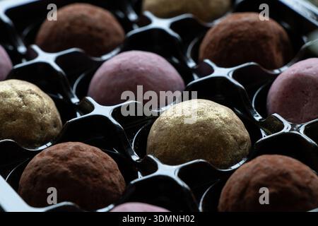 Les bonbons ronds multicolores sont placés dans un compartiment en plastique d'un paquet sur le thème des bonbons, des coffrets cadeaux, des desserts et des confiseries Banque D'Images