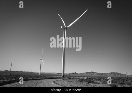 Un moulin à vent électrique géant avec la lune montrant à travers ses pales. Un parc éolien solaire entre Kingman AZ et Las Vegas Nevada. Noir a Banque D'Images