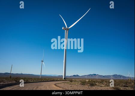 Un moulin à vent électrique géant avec la lune montrant à travers ses pales. Un parc éolien solaire entre Kingman AZ et Las Vegas Nevada. Banque D'Images
