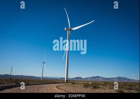 Un moulin à vent électrique géant avec la lune montrant à travers ses pales. Un parc éolien solaire entre Kingman AZ et Las Vegas Nevada. Banque D'Images