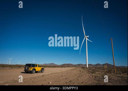 Un moulin à vent électrique géant avec la lune montrant à travers ses pales. Un parc éolien solaire entre Kingman AZ et Las Vegas Nevada. Banque D'Images