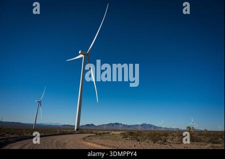 Un moulin à vent électrique géant avec la lune montrant à travers ses pales. Un parc éolien solaire entre Kingman AZ et Las Vegas Nevada. Banque D'Images