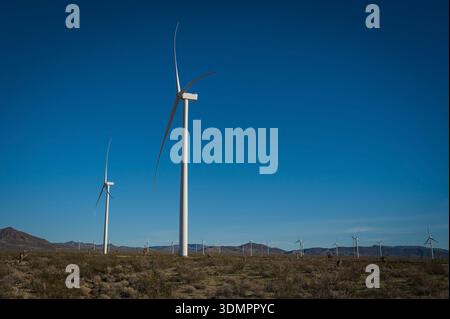 Un moulin à vent électrique géant avec la lune montrant à travers ses pales. Un parc éolien solaire entre Kingman AZ et Las Vegas Nevada. Banque D'Images