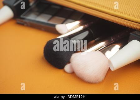 Outils de maquillage et palette sur un sac jaune Banque D'Images